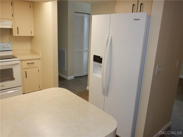 kitchen featuring white appliances and dark hardwood / wood-style floors