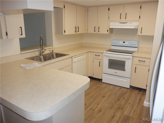 kitchen featuring sink, white appliances, light hardwood / wood-style floors, and kitchen peninsula