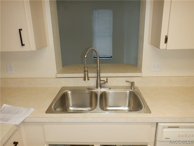 kitchen with sink, white cabinets, and white dishwasher