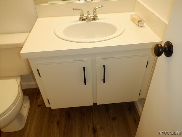 bathroom featuring toilet, sink, and hardwood / wood-style floors