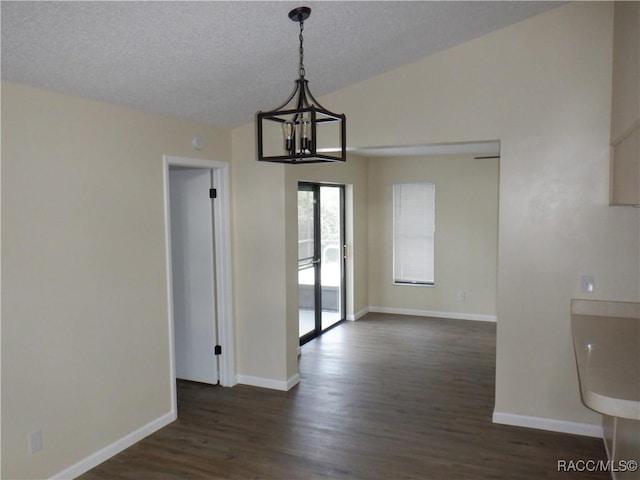 unfurnished dining area with an inviting chandelier, dark wood-type flooring, a textured ceiling, and vaulted ceiling