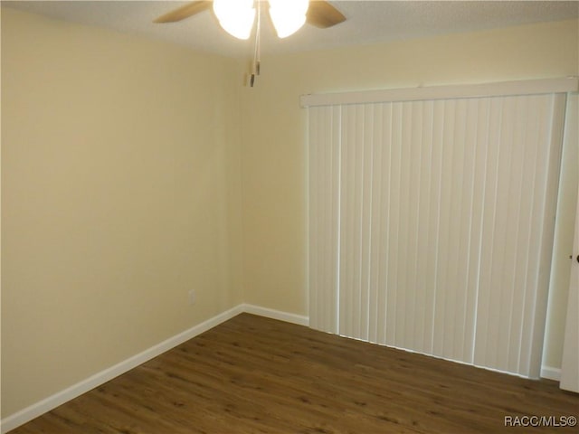 unfurnished room with dark wood-type flooring and ceiling fan