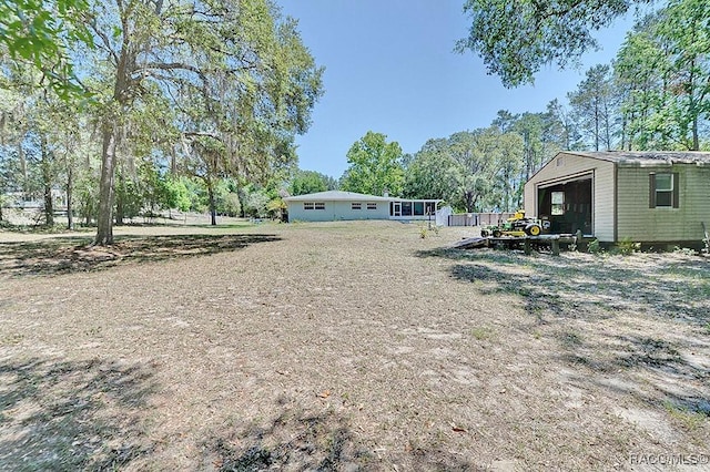 view of yard with a garage and an outbuilding