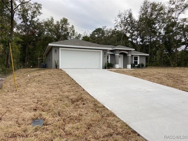 ranch-style home with a garage and a front lawn