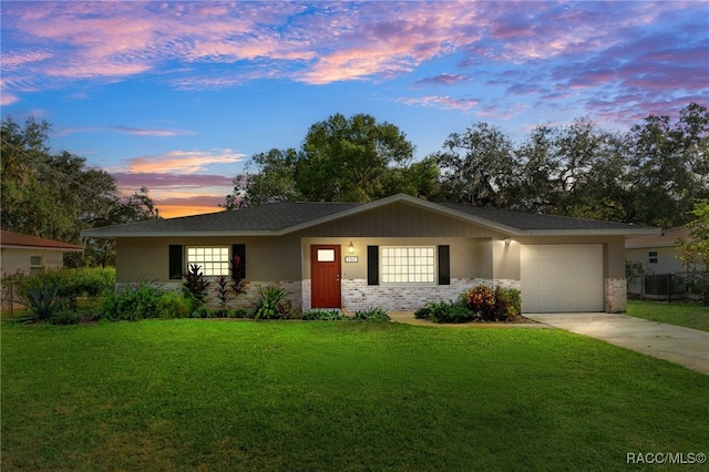 view of front of property with a garage and a yard