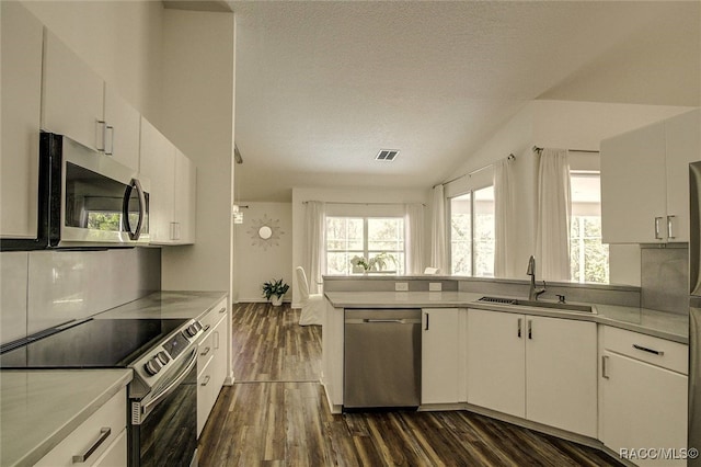 kitchen featuring white cabinets, appliances with stainless steel finishes, a textured ceiling, and sink