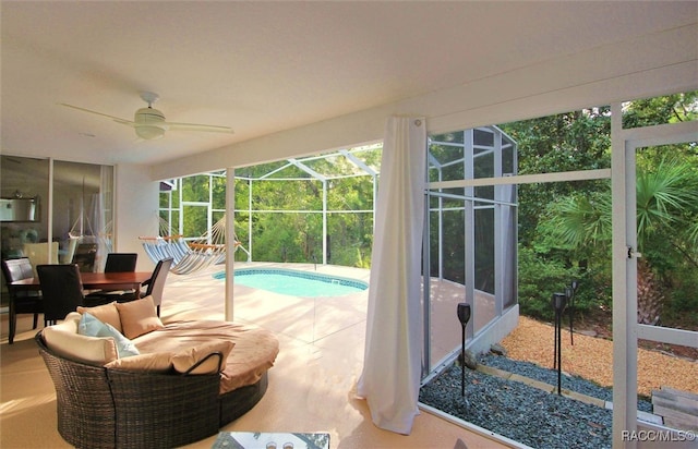 sunroom featuring ceiling fan and a pool