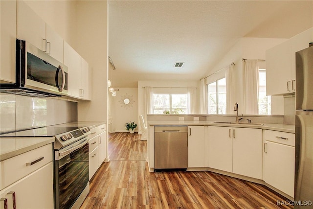 kitchen featuring hardwood / wood-style floors, sink, white cabinetry, and stainless steel appliances