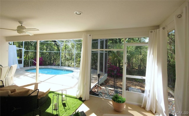 exterior space with glass enclosure, ceiling fan, and a patio area