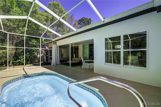 view of pool featuring glass enclosure, ceiling fan, and a patio