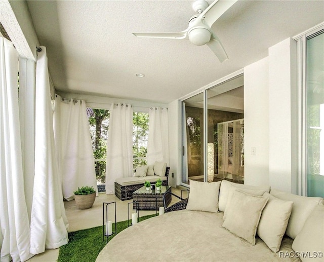 carpeted bedroom featuring ceiling fan and a textured ceiling