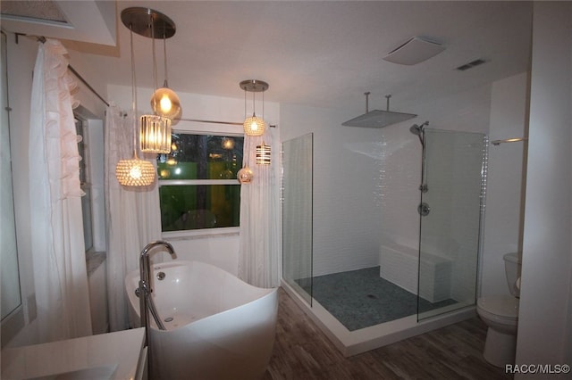 bathroom featuring hardwood / wood-style floors, toilet, and tiled shower