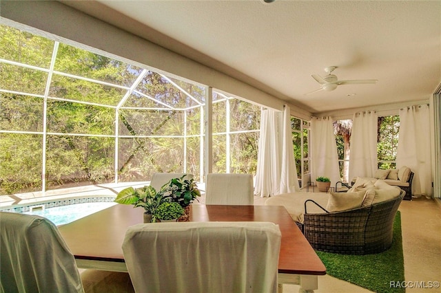 sunroom / solarium with ceiling fan, a healthy amount of sunlight, and a pool