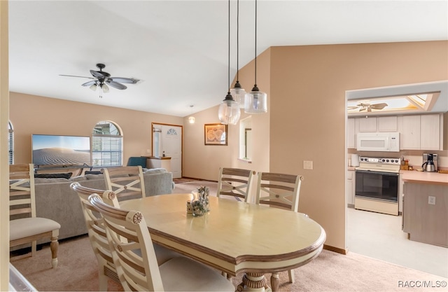 dining space with light carpet, ceiling fan, and vaulted ceiling