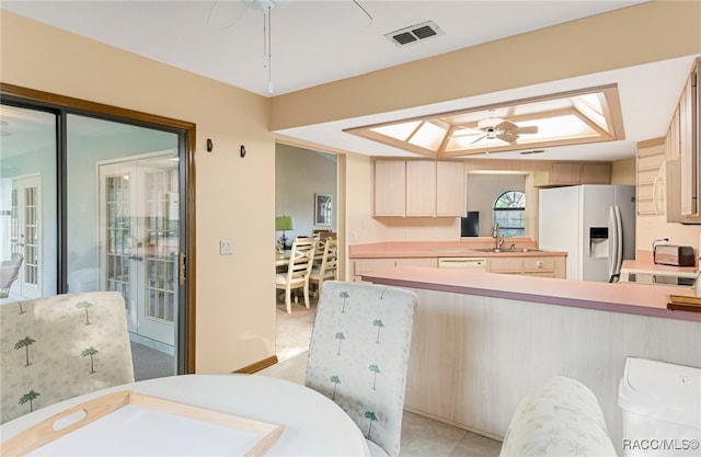 kitchen with ceiling fan, sink, and white refrigerator with ice dispenser