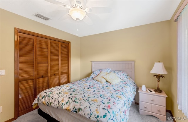 carpeted bedroom with ceiling fan and a closet