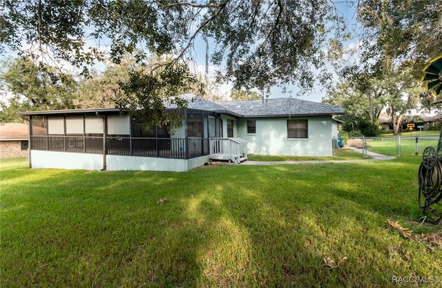 back of house with a lawn and a sunroom