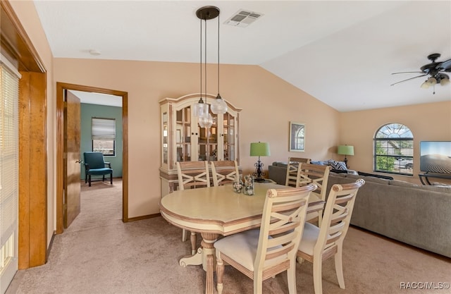 dining area with light carpet, ceiling fan, and vaulted ceiling