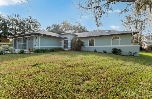 ranch-style house with a front lawn and a sunroom