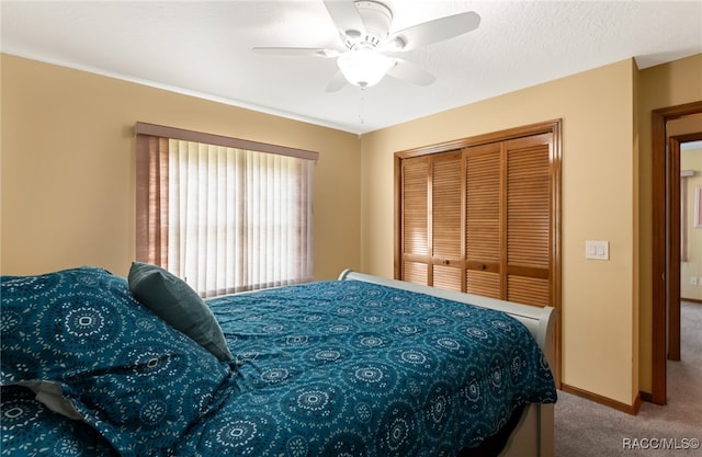 carpeted bedroom with ceiling fan and a closet