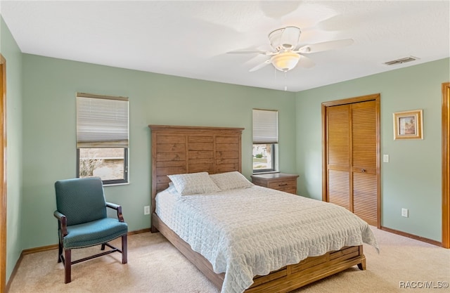 carpeted bedroom featuring multiple windows, a closet, and ceiling fan