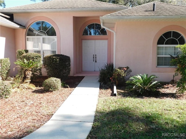 3201 N Canterbury Lake Dr, Hernando, FL 34442 - view of exterior entry featuring stucco siding and a shingled roof