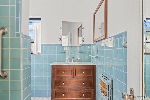 bathroom with vanity, heating unit, tile walls, and a healthy amount of sunlight