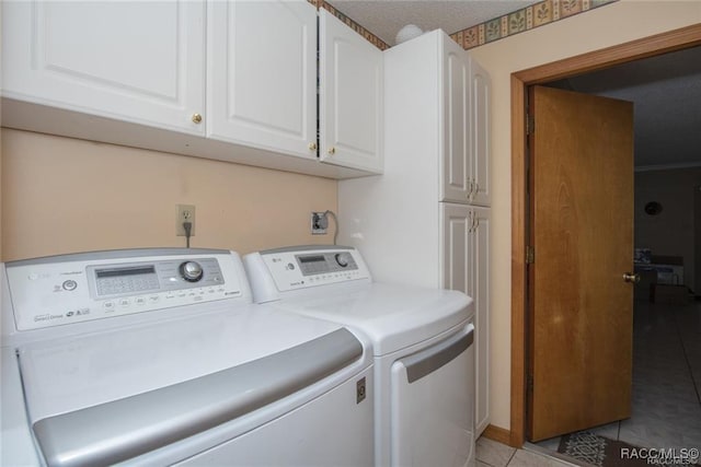 laundry room with light tile patterned flooring, cabinets, and independent washer and dryer