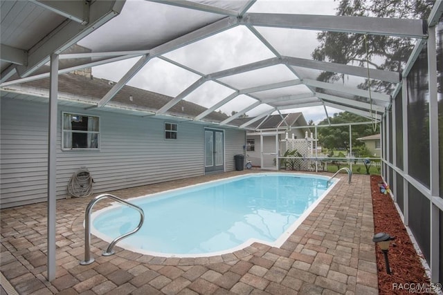 view of pool featuring glass enclosure and a patio