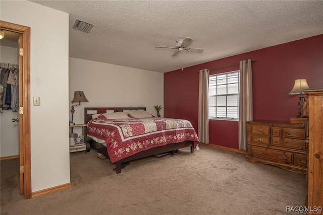 bedroom with carpet flooring, a spacious closet, a closet, and ceiling fan