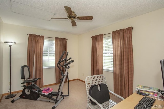 exercise area with light carpet, a textured ceiling, plenty of natural light, and ceiling fan