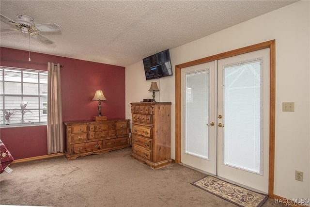 entryway featuring french doors, a textured ceiling, and carpet floors