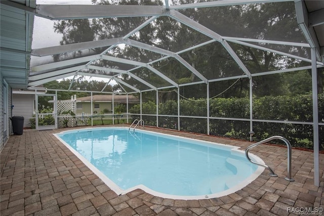 view of swimming pool featuring a patio area and a lanai