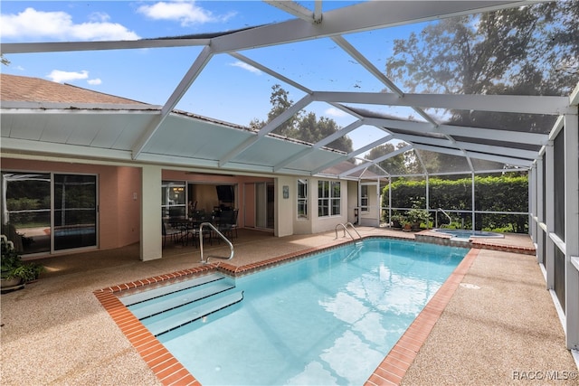 view of swimming pool with an in ground hot tub, a patio area, and a lanai