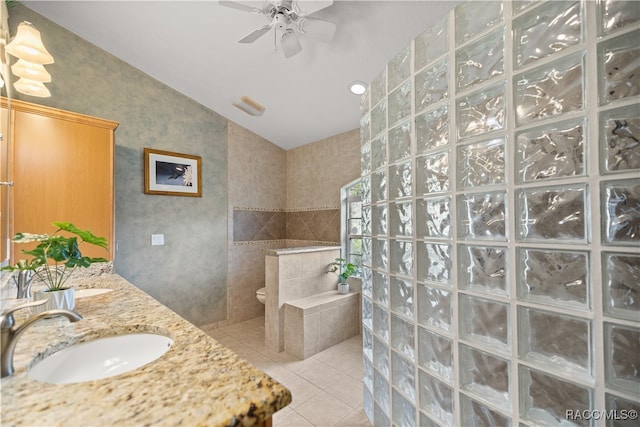 bathroom with walk in shower, vanity, ceiling fan, tile walls, and tile patterned flooring