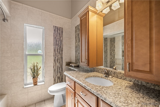 bathroom featuring tile patterned flooring, vanity, toilet, and tile walls