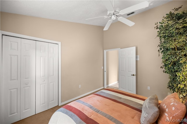 carpeted bedroom with a textured ceiling, a closet, vaulted ceiling, and ceiling fan