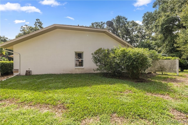 view of side of home with a yard