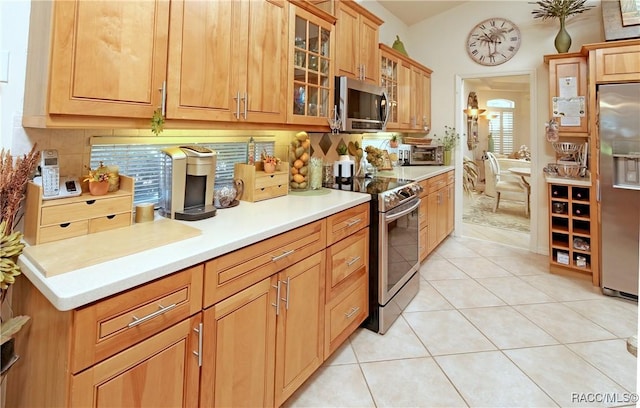 kitchen with decorative backsplash, light tile patterned flooring, and appliances with stainless steel finishes