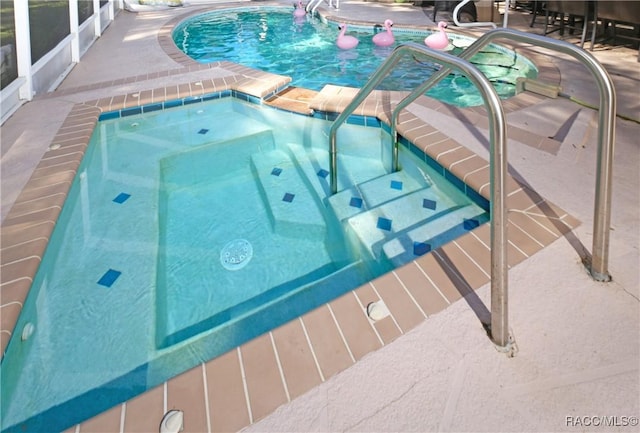 view of swimming pool with an in ground hot tub and a patio