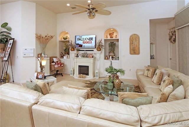 living room with ceiling fan, vaulted ceiling, light wood-type flooring, and built in shelves