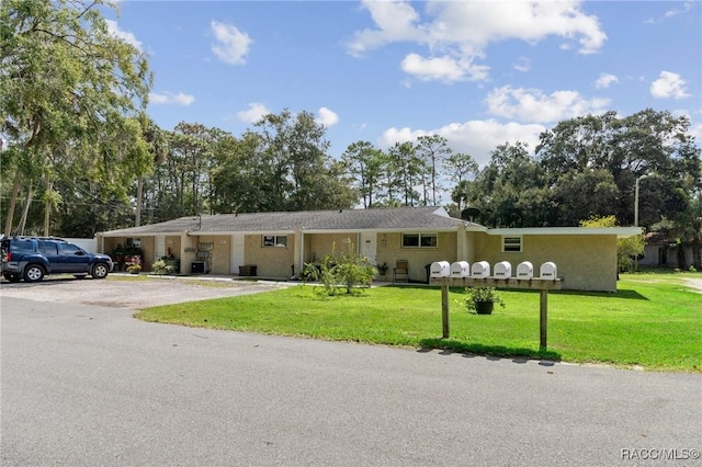 ranch-style house with aphalt driveway and a front yard