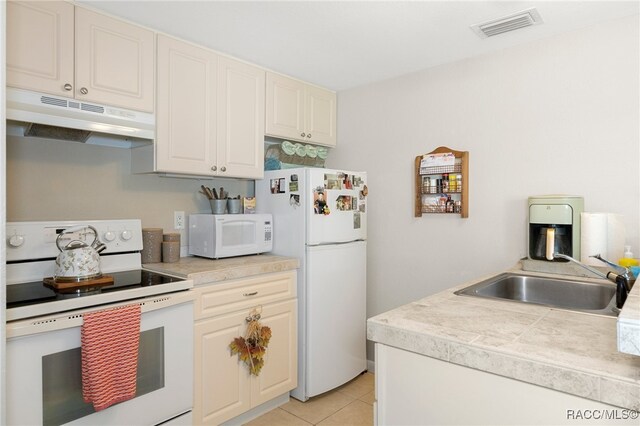 kitchen featuring visible vents, light countertops, a sink, white appliances, and under cabinet range hood