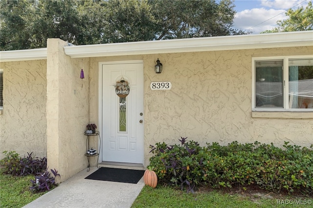 entrance to property featuring stucco siding