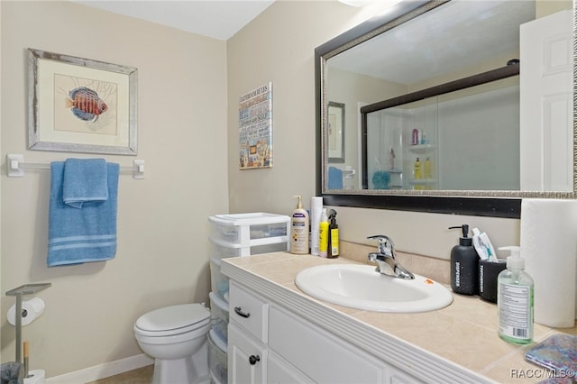 full bathroom with baseboards, toilet, vanity, and a shower stall