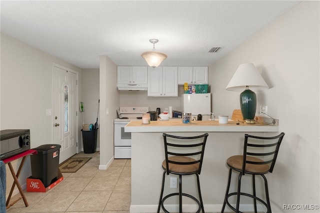 kitchen with a breakfast bar area, light countertops, white cabinetry, white appliances, and under cabinet range hood