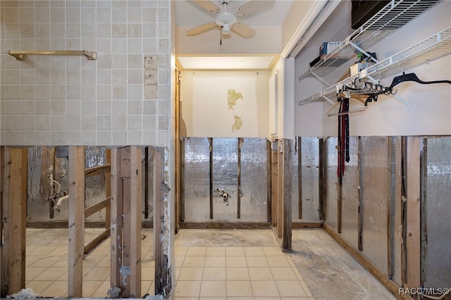 bathroom with ceiling fan and tile walls