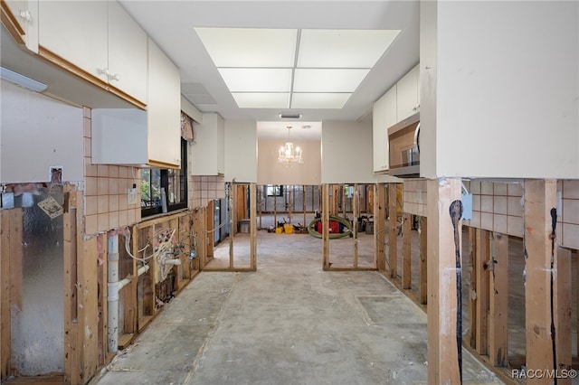 kitchen featuring white cabinets, a chandelier, and decorative light fixtures