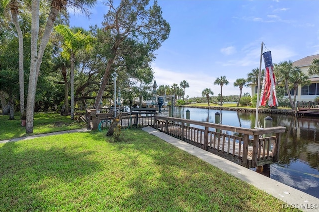 view of dock featuring a lawn and a water view