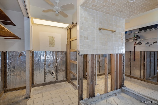 bathroom with ceiling fan and tile walls